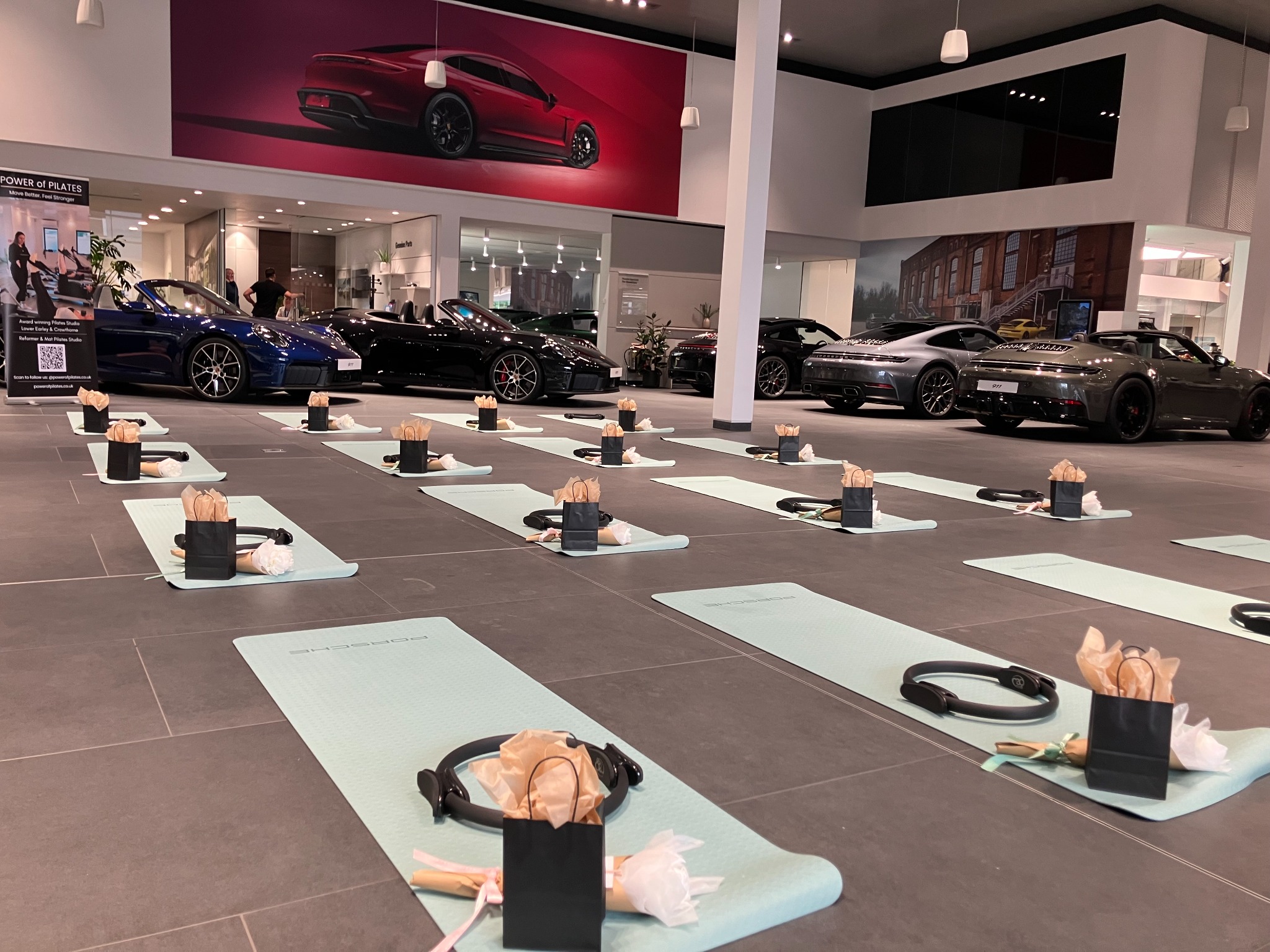 Power of Pilates mats set up inside Porsche Centre Reading showroom for Raise Your Heart Rate event